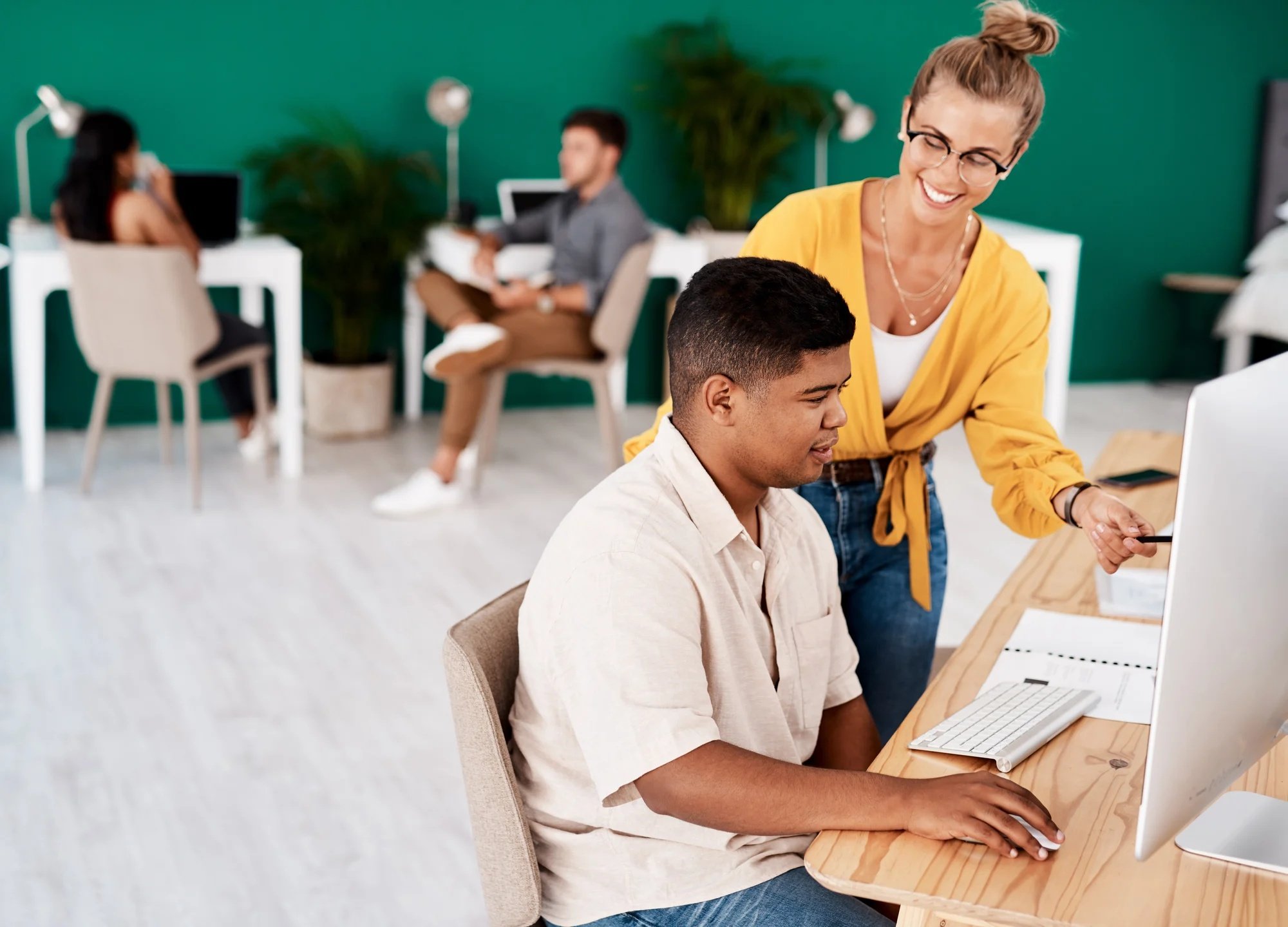 Profesora ayudando a un alumno con un ordenador
