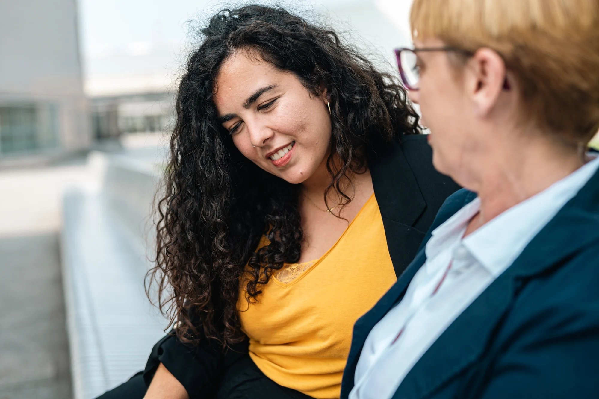 Dos mujeres mirando a un mismo dispositivo digital en una oficina.
