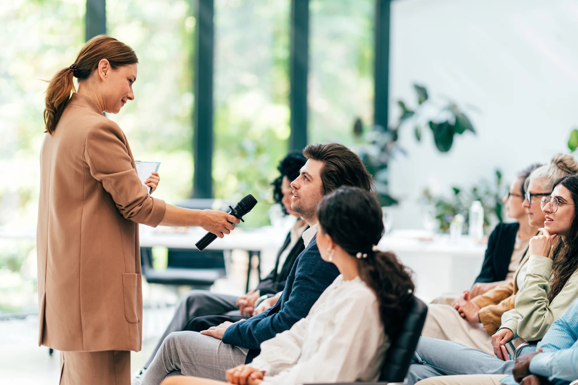 Mujer con micrófono en una charla con más personas