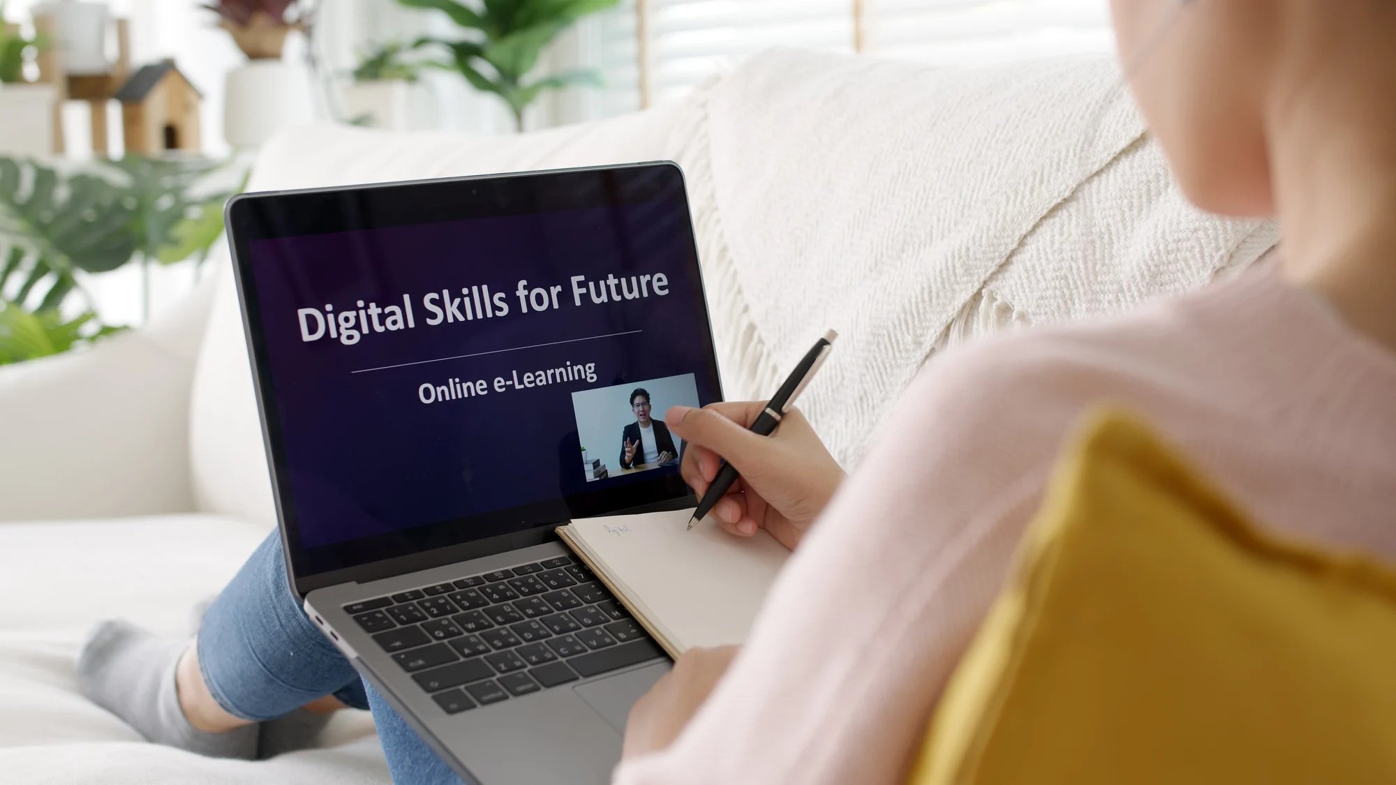 Mujer estudiando con un ordenador en cuya pantalla hay una clase online sobre Digital Skills for Future