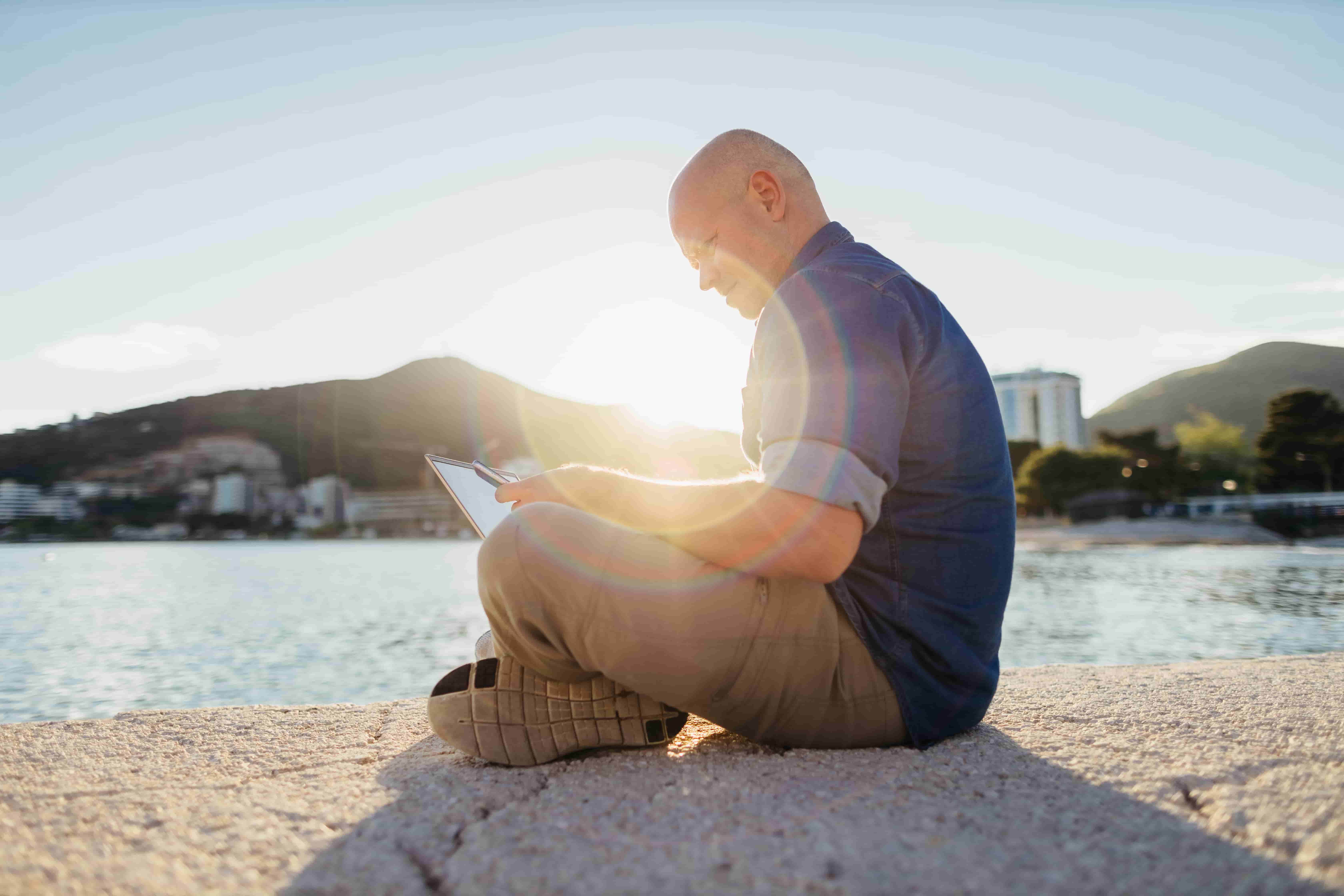 Empresario con una tablet en la playa
