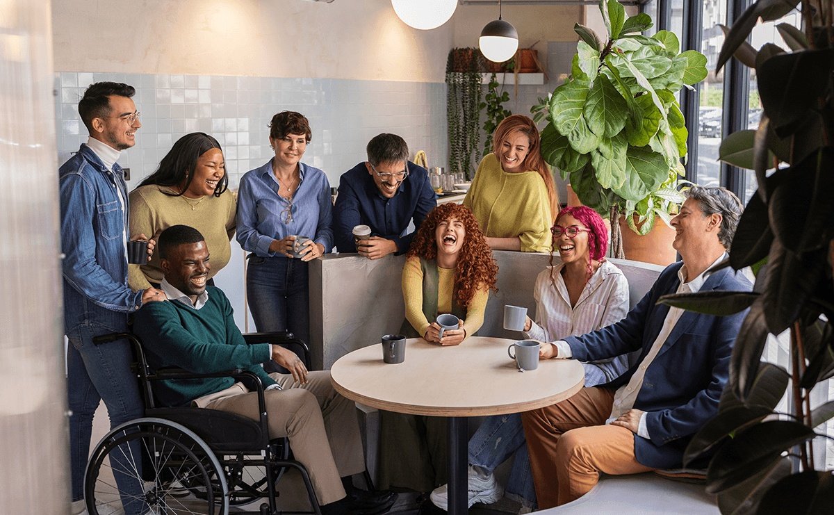 Grupo de personas diversas riendo en una cafetería