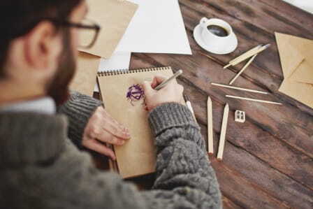Hombre dibujando en un cuaderno