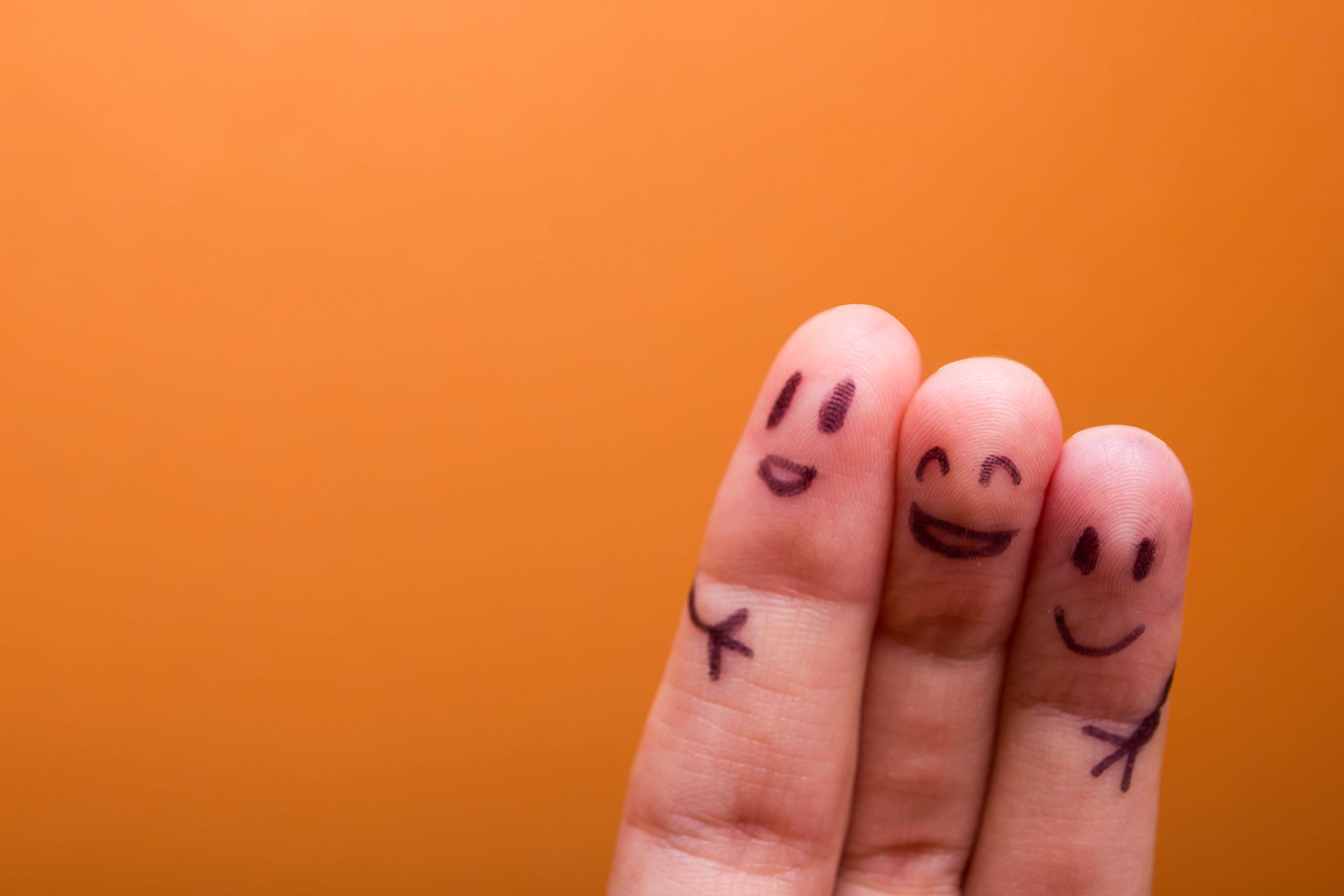 Dedos con caras sonrientes dibujadas abrazados