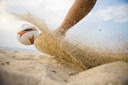 Persona jugando al fútbol en la arena