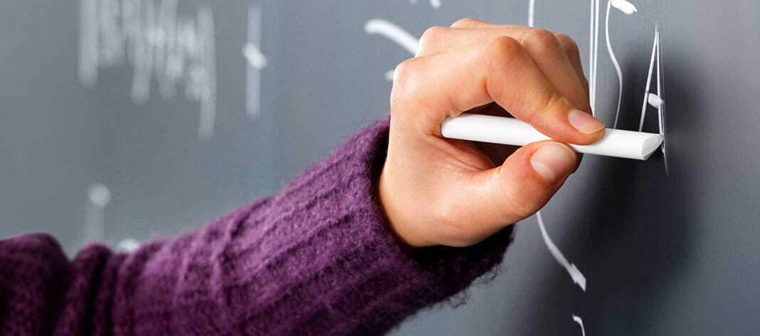 Mano escribiendo en una pizarra