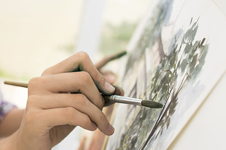 Mano pintando un lienzo